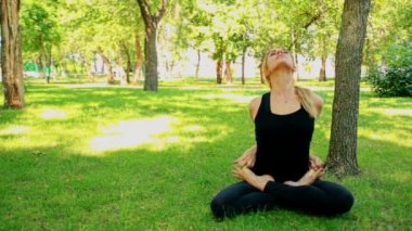 Yoga park yaparken geniş çekim genç kadın