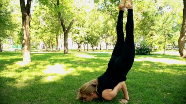 Brede shot jonge vrouw doen yoga in park — Stockvideo