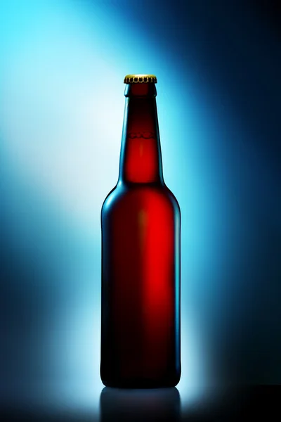 Botella de cerveza en botella marrón con ruta de recorte sobre fondo azul degradado — Foto de Stock