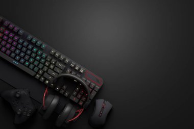 Oyun alanının üst görüntüsü ve fare, klavye, joystick, siyah masa arka planındaki kulaklık gibi teçhizatlar. Canlı yayın konsepti için aksesuarların 3D yorumlaması