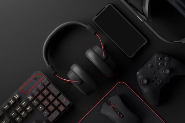 Oyun alanının üst görüntüsü ve fare, klavye, joystick, kulaklık, siyah masa arka planında VR kulaklık gibi teçhizatlar. Canlı yayın konsepti için aksesuarların 3D yorumlaması