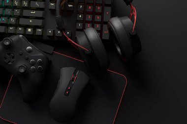 Oyun alanının üst görüntüsü ve fare, klavye, joystick, kulaklık, siyah masa arka planında VR kulaklık gibi teçhizatlar. Canlı yayın konsepti için aksesuarların 3D yorumlaması