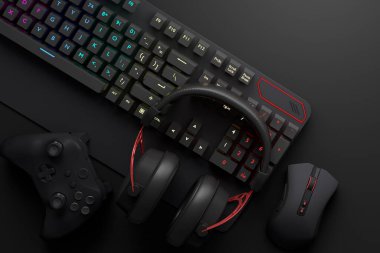 Oyun alanının üst görüntüsü ve fare, klavye, joystick, siyah masa arka planındaki kulaklık gibi teçhizatlar. Canlı yayın konsepti için aksesuarların 3D yorumlaması