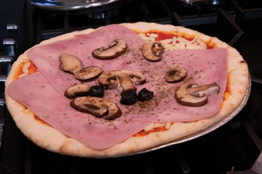 Jambon, zeytin ve mantarlı taze ev yapımı pizza.