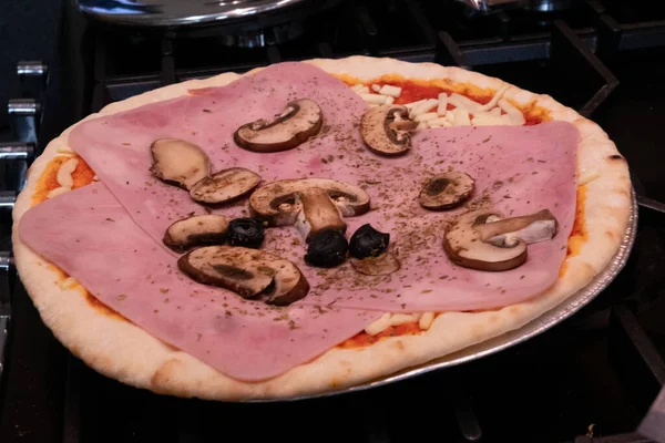 Jambon, zeytin ve mantarlı taze ev yapımı pizza.
