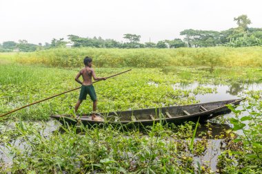 küçük çocuk bir tekne içinde duruyor