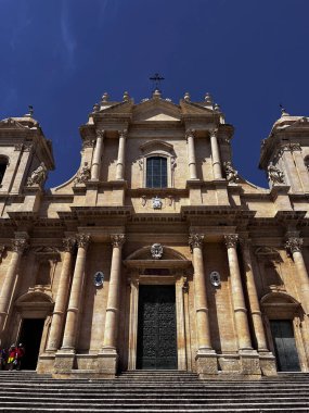 Barok katedral cephesi açık mavi gökyüzünün altında.