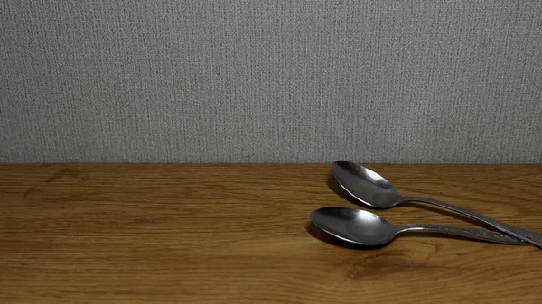 Ahşap bir yüzeyde duran iki gümüş kaşığın yakın çekimi..