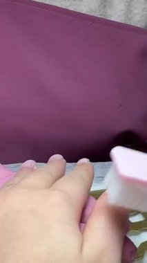 Manikürcü müşterinin elini törpüledikten sonra tırnak tozunu temizleyerek, temiz ve hijyenik tırnak prosedürünün bir parçası olarak. Yüksek kalite 4k görüntü