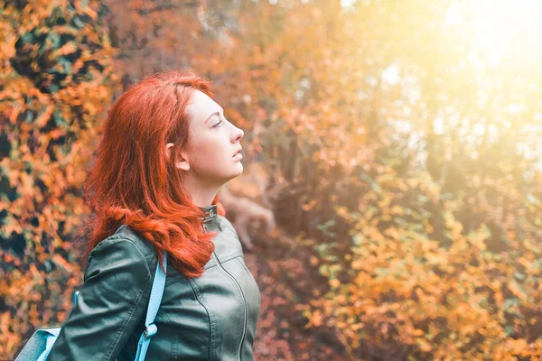 Ung kvinna på bakgrunden av en fallande skog. — Stockfoto