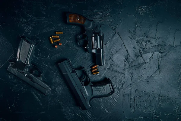 Three guns and bullets on black table. — Stock Photo, Image