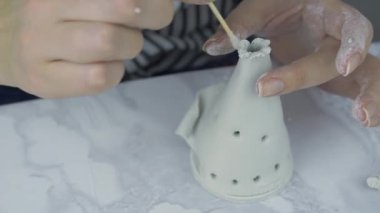 Kişi mermer masadaki beyaz çamurdan wigwam yapar. 
