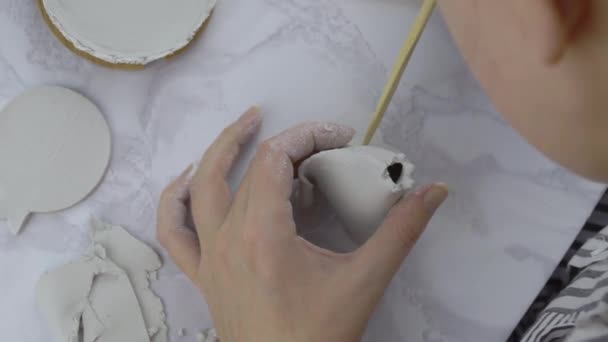 Жіночі руки роблять отвори у вігвамі з глини з дерев'яною паличкою . — стокове відео