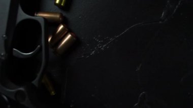 Ateşli silahlar ve mühimmat siyah desenli bir masada yatıyor.. 