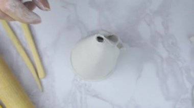 Kadın, beyaz kilden yapılmış boş bir bıçakla kesikler yapıyor.. 