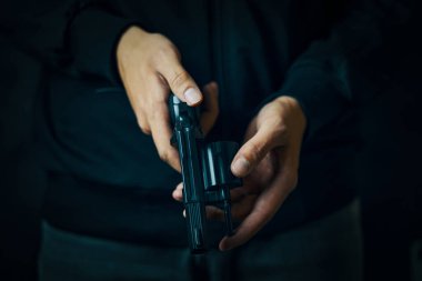 Bir adamın tabancayı doldurmasına yaklaş..