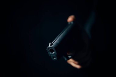 Elinde siyah bir tabanca var..