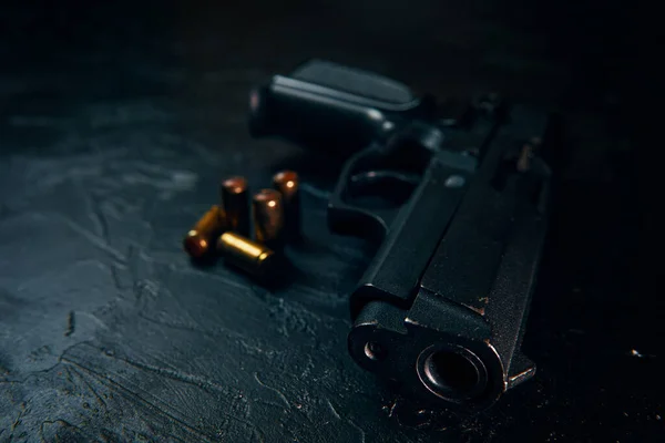 Pistola preta e balas na mesa. — Fotografia de Stock