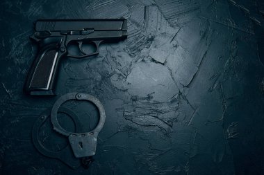 Tabanca ve kelepçe desenli masada..