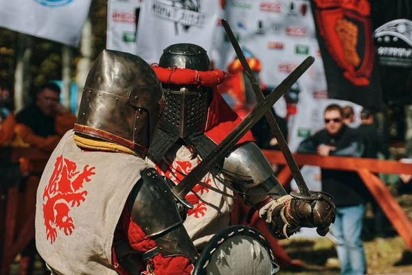 Dos caballeros con un león en la ropa pelean con espadas. — Foto de Stock