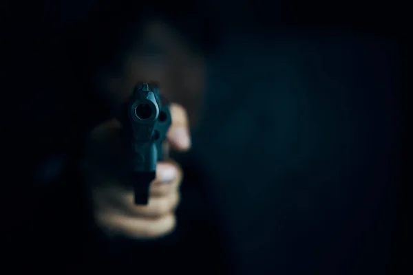 Muzzle of gun in mans hand är riktad mot kameran. — Stockfoto