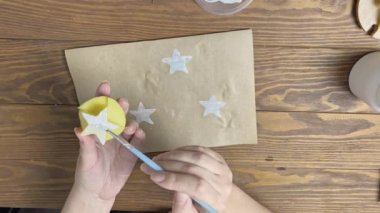 Kadın el işi kağıtlarını patatesle süslüyor..