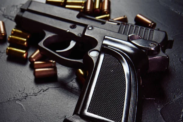 Pistola preta com cartuchos na mesa. — Fotografia de Stock