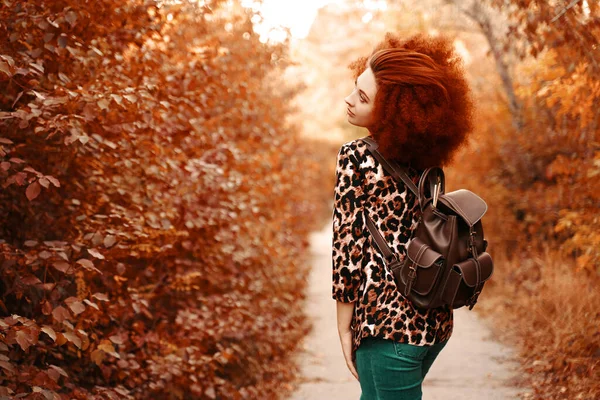 Kvinna med afro promenader i parken på hösten — Stockfoto