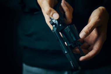 Erkekler tabanca namlusundaki mermileri kontrol eder..