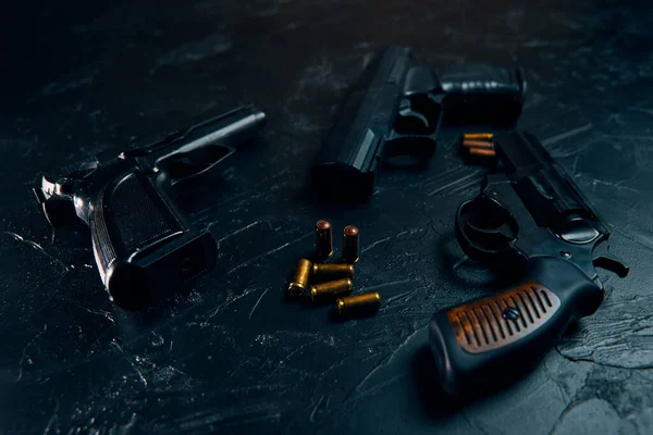 Three guns and bullets on black table. — Stock Photo, Image