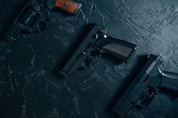 Três armas na mesa preta. — Fotografia de Stock