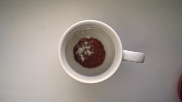 Mans hand häller sked kaffe och grädde i keramikmugg. — Stockvideo