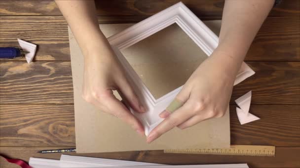 Vrouwen handen lijmen frames gemaakt van piepschuim. — Stockvideo