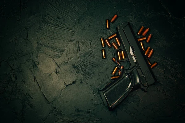 Pistola con cartucce su tavolo di cemento scuro. — Foto Stock