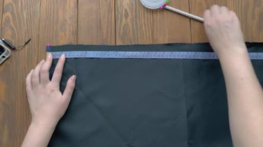 Terzi kadın ahşap masada çalışıyor..