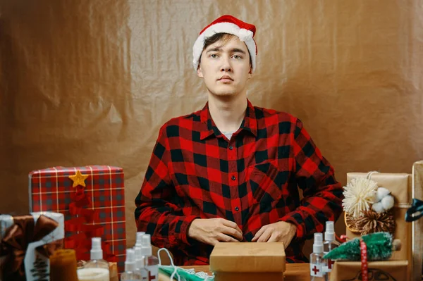 Ragazzo in camicia a quadri e cappello di Babbo Natale in decorazioni natalizie. — Foto Stock