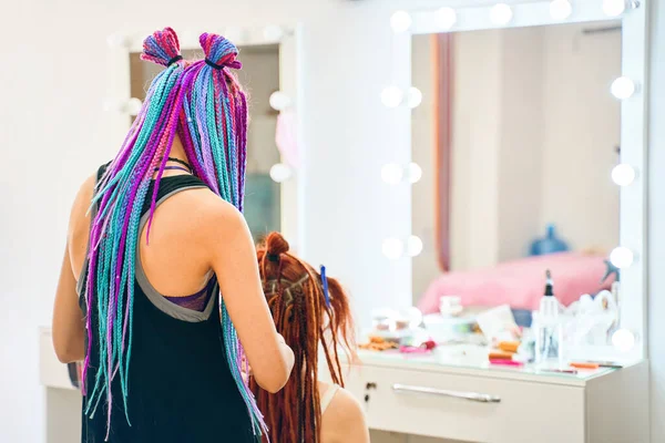 Hairdresser with colored afro braids weaves ginger dreadlocks. — Stock Photo, Image