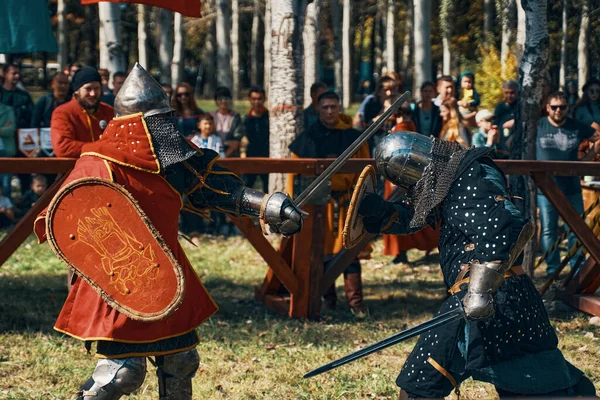 Batalha de cavaleiros na arena. Espadas, escudos, capacetes e armaduras. — Fotografia de Stock