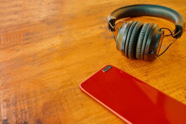 Kulaklık ve akıllı telefon ahşap masada..