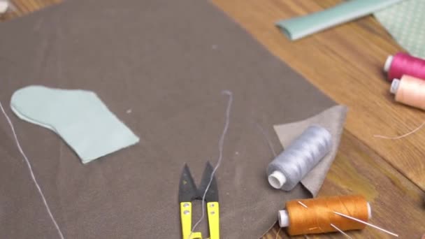 Scissors, cloth and thread with needles on wooden table. — Stock Video