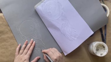 Kadınların elleri, Eva köpüğünden kırtasiye bıçağıyla desenleri kesiyor..