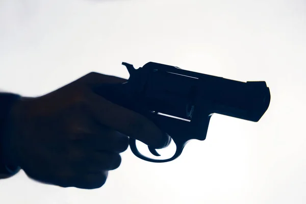 Silhouette of mans hand with revolver on white background. — Stock Photo, Image