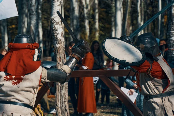 Dos caballeros con armadura imitan una pelea de espadas. — Foto de Stock