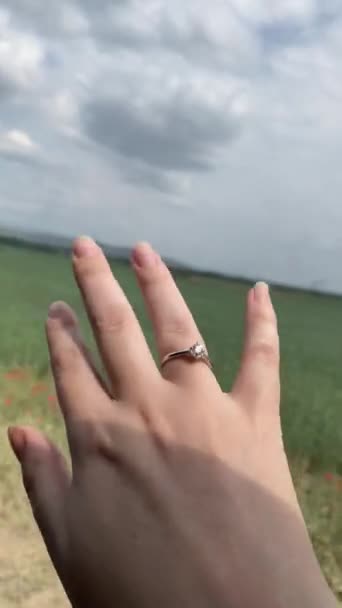 Mujeres mano con anillo de compromiso en el fondo de los campos. — Vídeo de stock