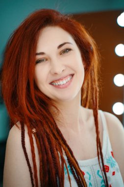Gülümseyen kızıl saçlı uzun saçlı kız..