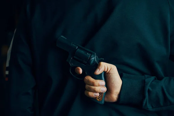 En man med en revolver på ryggen. — Stockfoto