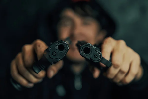 Két pisztoly van az ember kezében, a kamerára céloznak.. — Stock Fotó