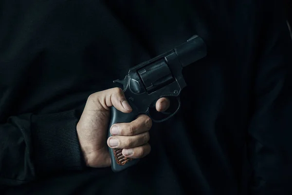 Um homem com um revólver nas costas. — Fotografia de Stock