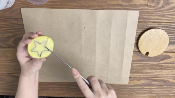 Dámské ruce vyřezávat hvězdu z brambor s nožem a forma sušenky. — Stock video