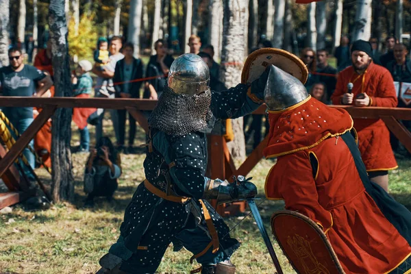 Batalla de caballeros en la arena. Espadas, escudos, cascos y armaduras. — Foto de Stock